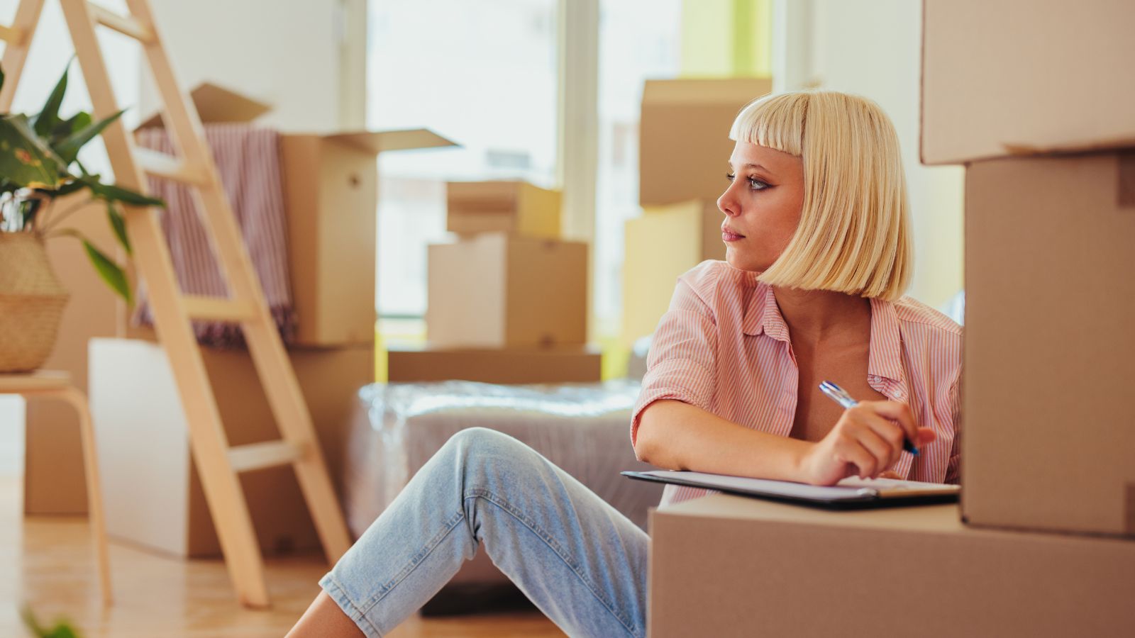 A woman making a packing list to move abroad.