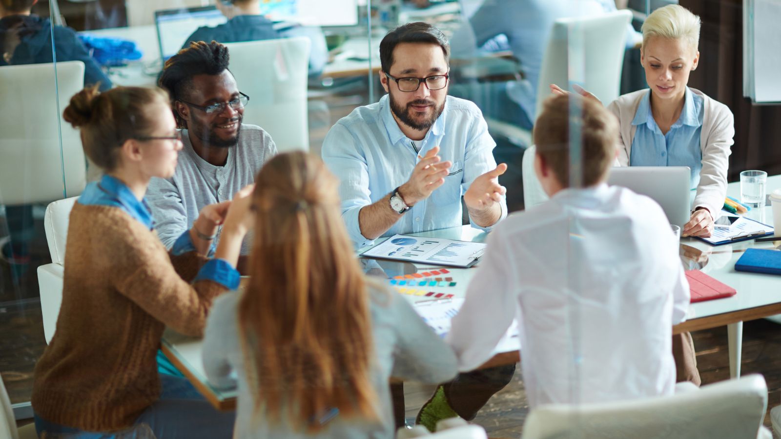 Team working collaboratively in a modern glass office.